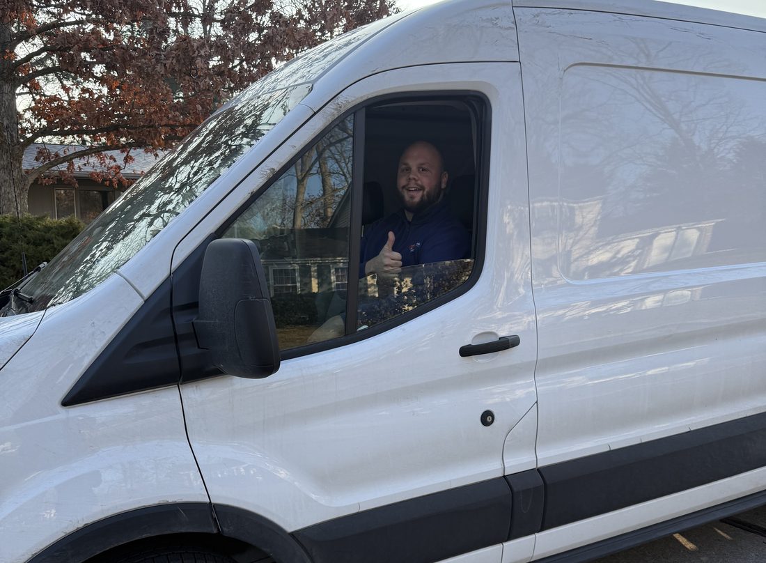 A Commodore Heating & Cooling technician giving a thumbs-up from the service van in Toledo